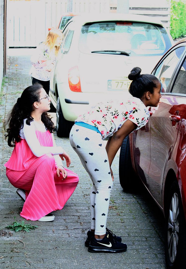 RAK with Children hiding behind car